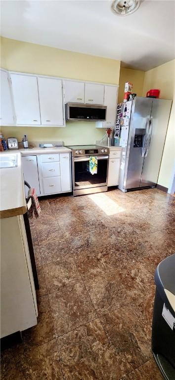 kitchen featuring stainless steel appliances, ventilation hood, light countertops, and white cabinetry