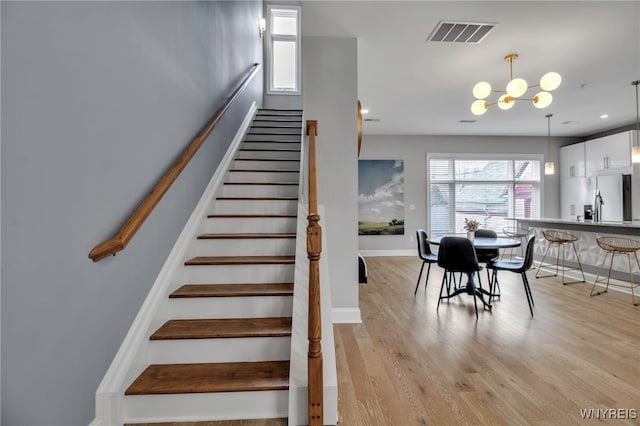 stairway featuring recessed lighting, visible vents, wood finished floors, a chandelier, and baseboards