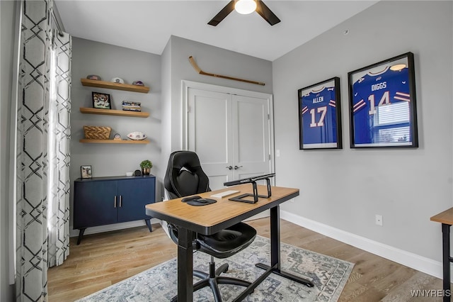 office area featuring baseboards, a ceiling fan, and light wood-style floors