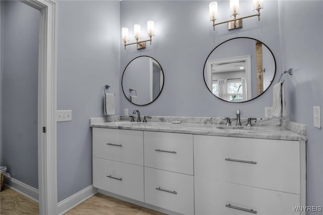 full bathroom with a sink, baseboards, and double vanity