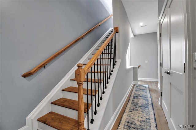 staircase with baseboards and wood finished floors