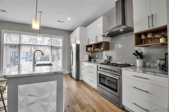 kitchen with a sink, visible vents, wall chimney range hood, appliances with stainless steel finishes, and open shelves