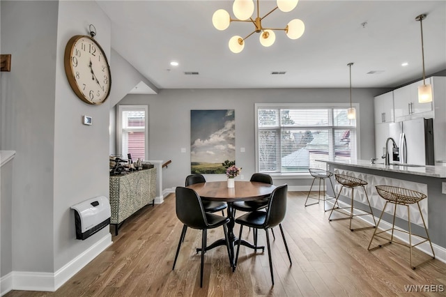 dining area featuring heating unit, baseboards, visible vents, and wood finished floors