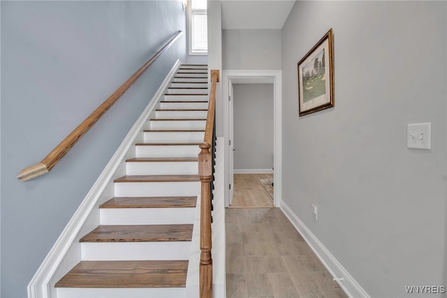 stairway with baseboards and wood finished floors