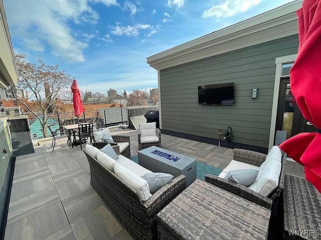 view of patio with outdoor dining area and an outdoor living space with a fire pit