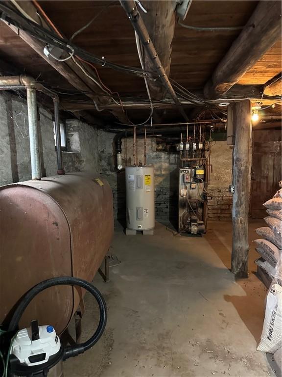 unfinished basement featuring heating fuel, a heating unit, and electric water heater