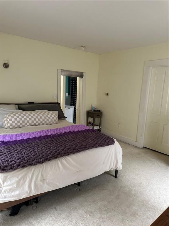 bedroom featuring baseboards and light colored carpet