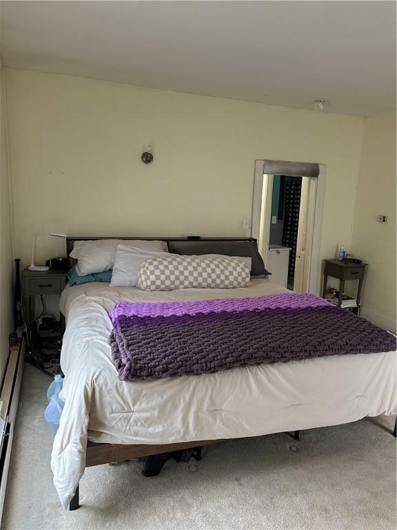 bedroom with carpet floors and baseboard heating