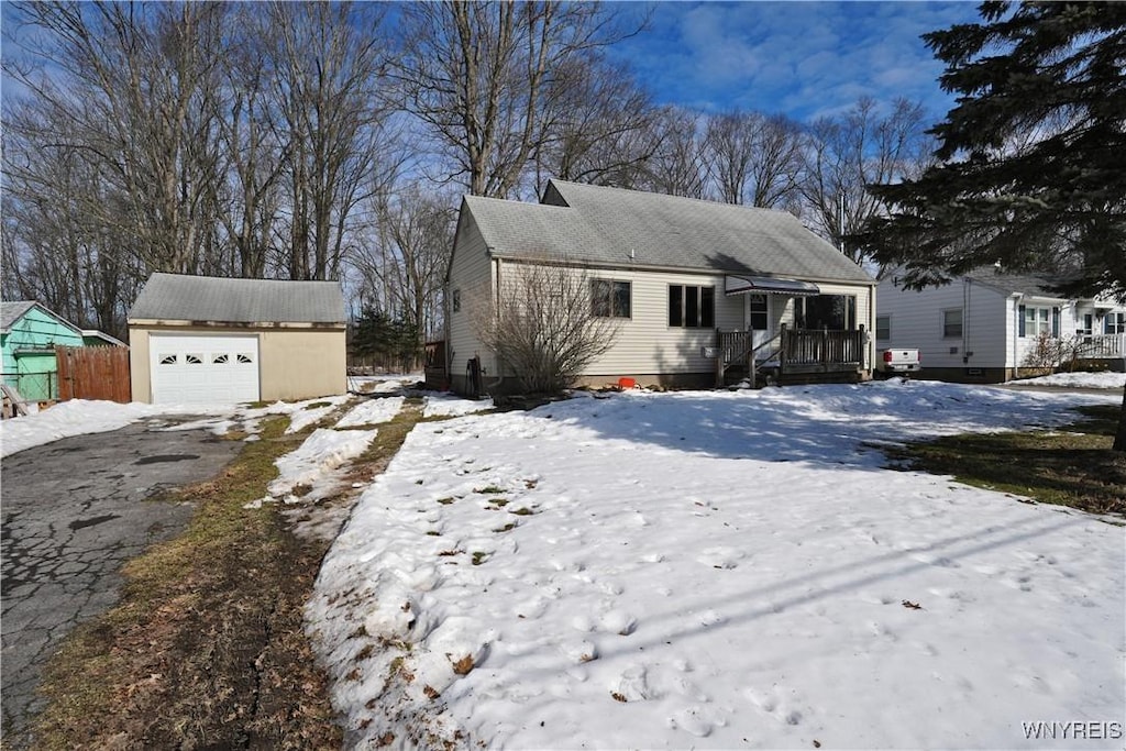 view of front of house with a garage, an outbuilding, and aphalt driveway