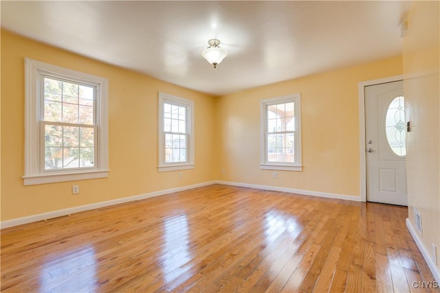 entryway featuring light wood finished floors, visible vents, and baseboards