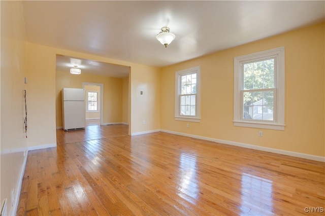 spare room with light wood finished floors and baseboards