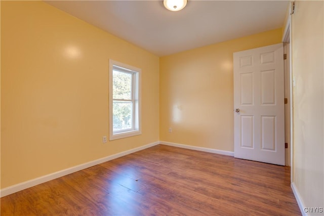 empty room featuring baseboards and wood finished floors