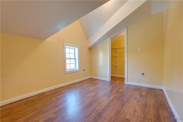 bonus room with vaulted ceiling, wood finished floors, and baseboards