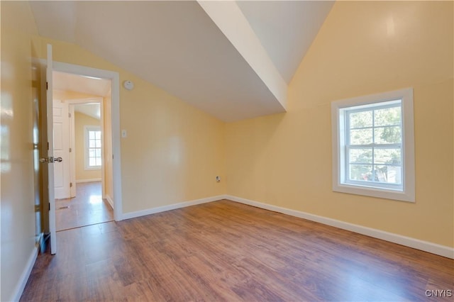 additional living space featuring lofted ceiling, wood finished floors, and baseboards