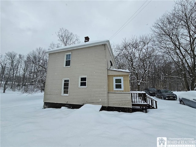 snow covered house with a deck