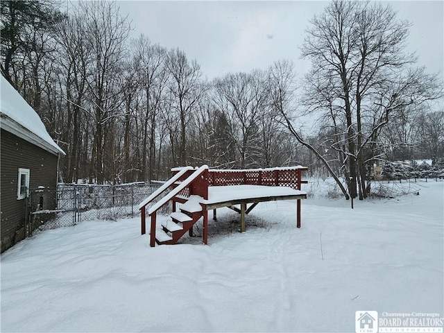 snowy yard featuring stairs and fence