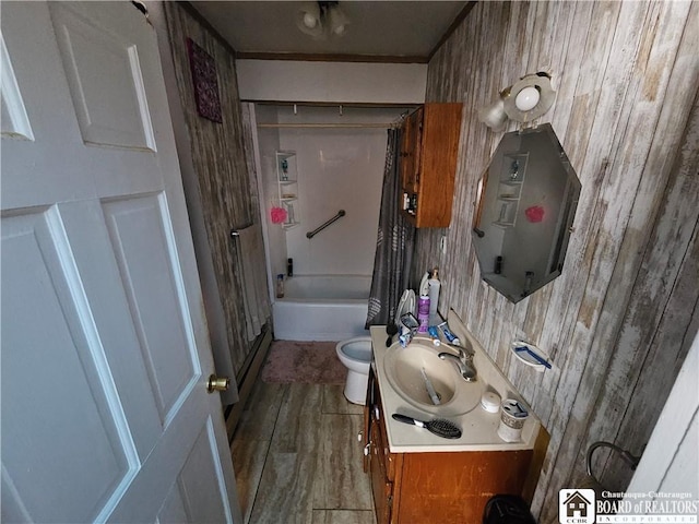 bathroom with shower / bathtub combination with curtain, vanity, toilet, and wood finished floors