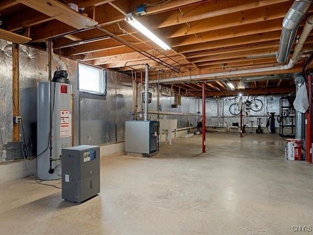 below grade area featuring a heating unit, water heater, and a sink