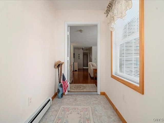 hallway featuring radiator heating unit, a baseboard radiator, and baseboards