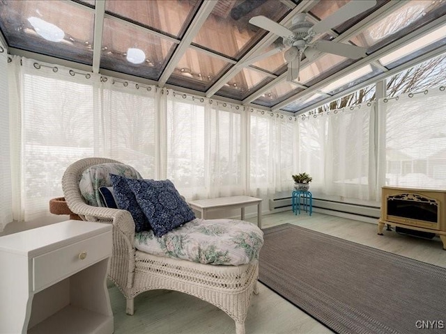 sunroom / solarium with a ceiling fan and baseboard heating