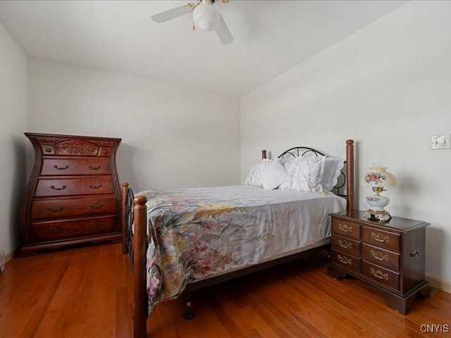 bedroom with a ceiling fan, baseboards, and wood finished floors