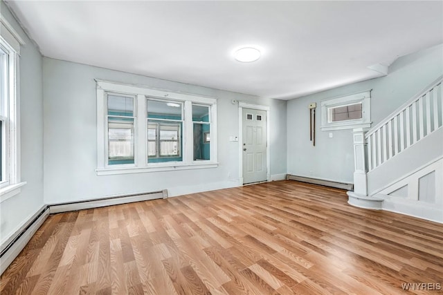 foyer with baseboards, a baseboard radiator, stairway, wood finished floors, and baseboard heating