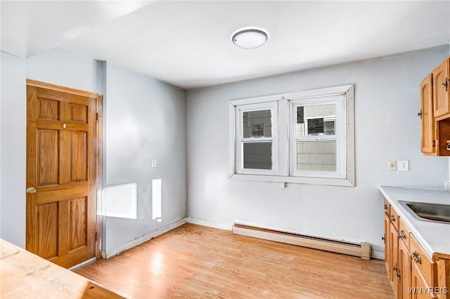 unfurnished dining area with a baseboard radiator and light wood-style flooring