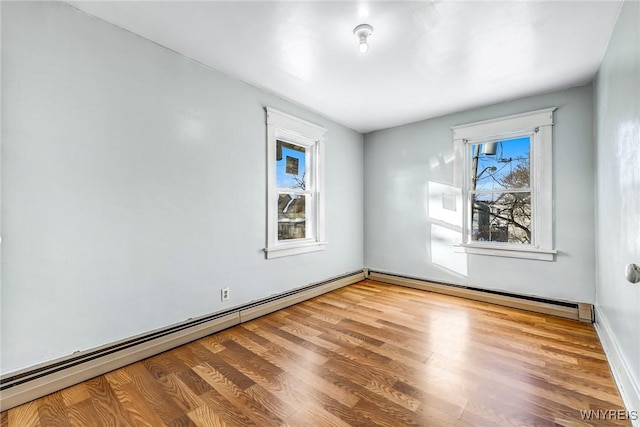 unfurnished room with a baseboard radiator, baseboard heating, and wood finished floors