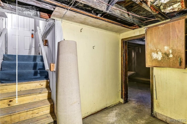 interior space with stairs and unfinished concrete flooring