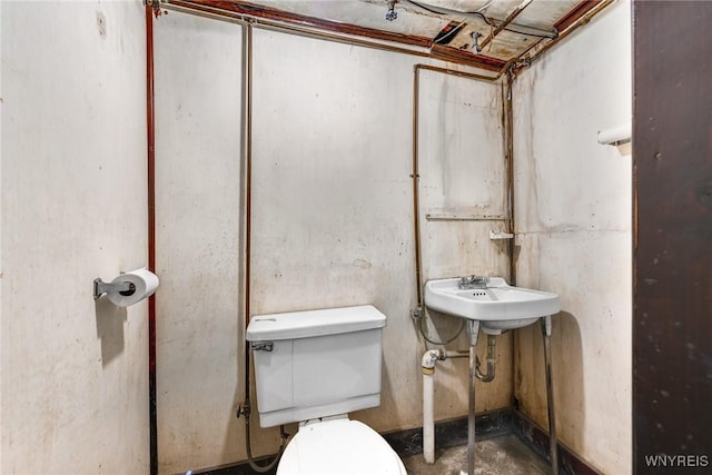 bathroom with toilet and concrete flooring