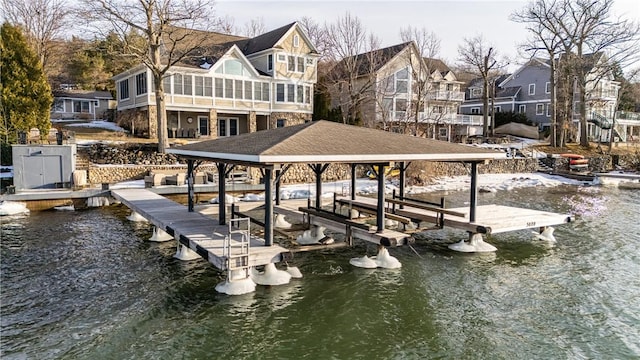 view of dock with a water view, boat lift, and a residential view