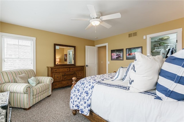 bedroom featuring ceiling fan, light colored carpet, visible vents, a spacious closet, and a closet