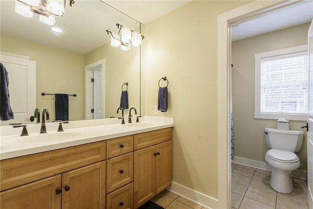 full bath featuring double vanity, tile patterned flooring, baseboards, and a sink