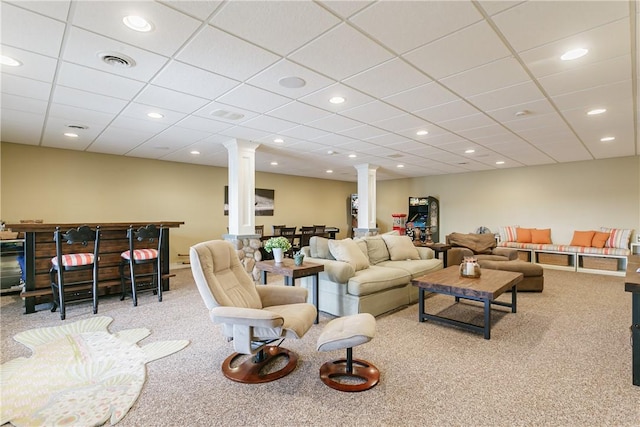 carpeted living area with visible vents, a paneled ceiling, decorative columns, and recessed lighting