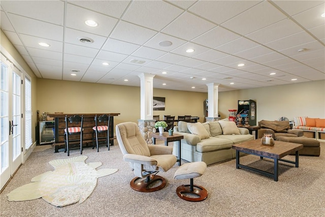 carpeted living room featuring a paneled ceiling, decorative columns, and recessed lighting