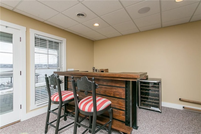 bar with carpet flooring, beverage cooler, visible vents, and a dry bar