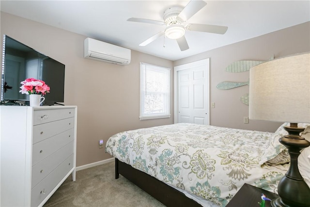 carpeted bedroom featuring a wall unit AC, ceiling fan, baseboards, and a closet