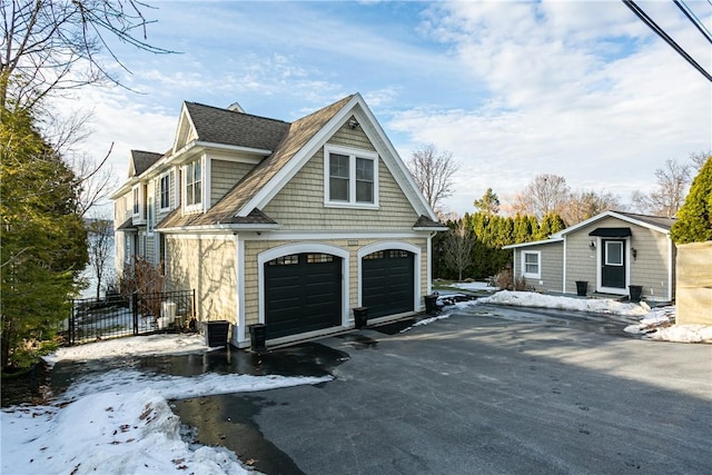 view of front of property featuring driveway, fence, and central AC