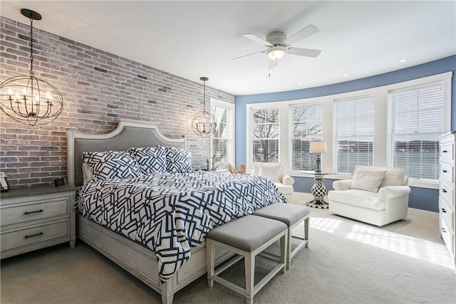 bedroom with brick wall, multiple windows, and a notable chandelier