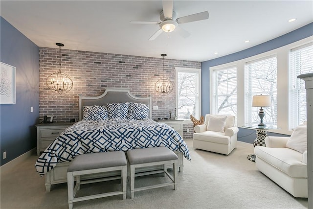 carpeted bedroom featuring an inviting chandelier, brick wall, and baseboards