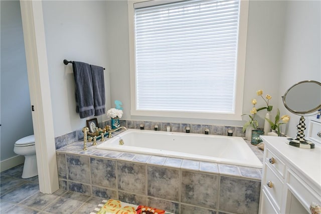 full bath featuring vanity, a garden tub, and toilet