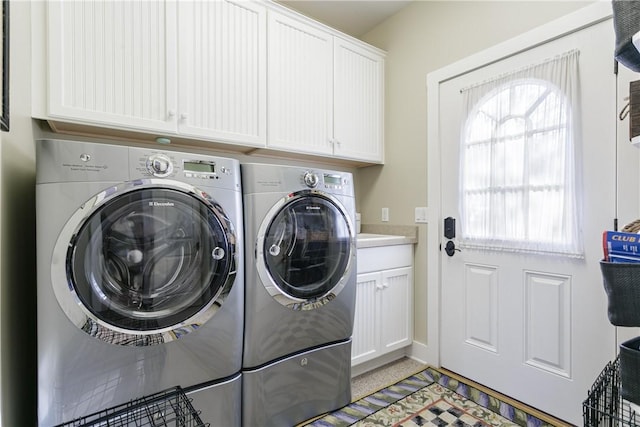 washroom featuring cabinet space and separate washer and dryer