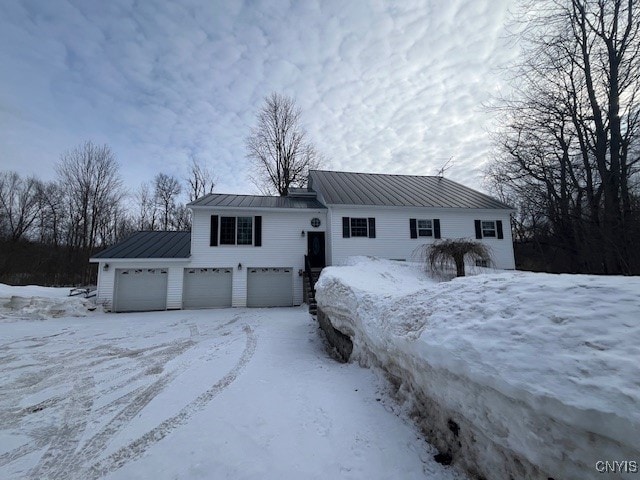 view of front of house featuring a garage, metal roof, and a standing seam roof