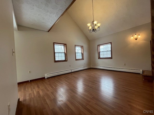 empty room featuring high vaulted ceiling, wood finished floors, a textured ceiling, and an inviting chandelier