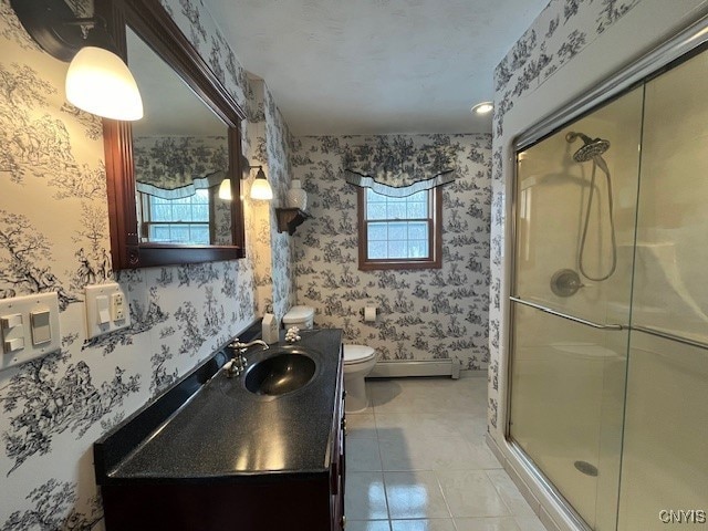 full bathroom with wallpapered walls, a stall shower, toilet, tile patterned flooring, and a baseboard heating unit