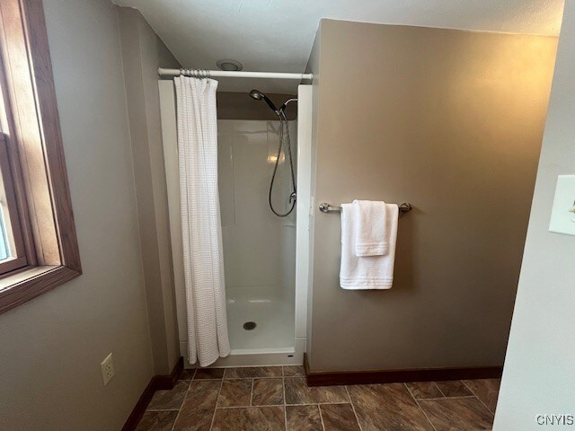 full bathroom featuring baseboards and a shower with shower curtain