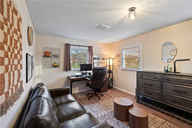 office with baseboards, visible vents, and wood finished floors