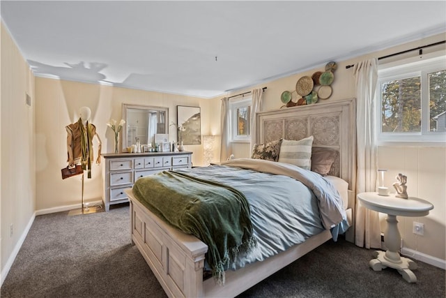 bedroom with dark colored carpet, multiple windows, and baseboards