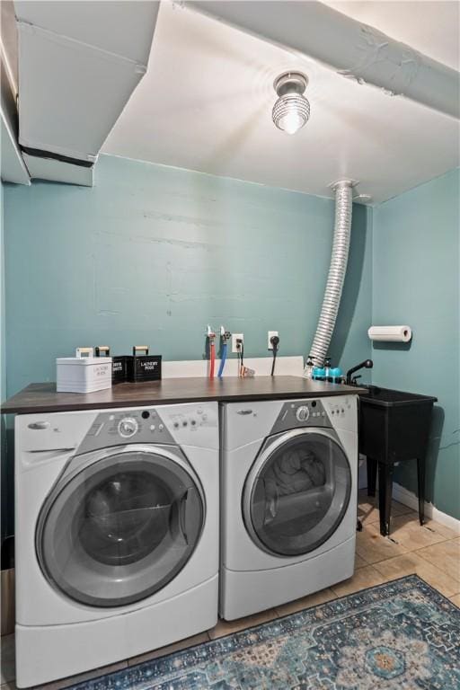 laundry area featuring laundry area, washing machine and dryer, light tile patterned floors, and baseboards