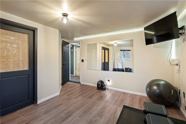 exercise room with baseboards and wood finished floors